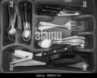 Offene Schublade mit Besteck – Draufsicht. Einfarbige Farbtöne Stockfoto