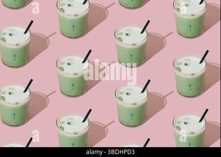 Kreatives Sommermuster aus gefrorenem Matcha-Latte auf pastellrosa Hintergrund. Minimales gesundes Matcha Latte Konzept. Trendige Drink-Idee. Stockfoto