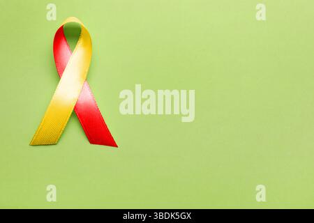 World Hepatitis Day. Gelb-rotes Farbband auf hellgrünem Hintergrund, Draufsicht. Leerzeichen für Text Stockfoto