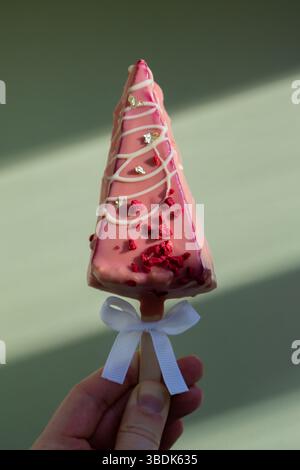 Neuer Look des trendigen Mini-Eis-Käsekuchens auf Stock in leuchtend rosa Farbe auf pastellfarbenem Hintergrund. Kopierraum Mustervorlage für Bäckerei Mini Dessert Coffee Shop. Kuchen zum Mitnehmen Süße Weihnachtsgeschenk-Idee eine Person Stockfoto