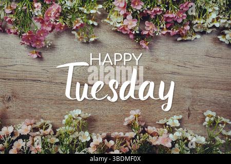 Happy Tuesday Textnachricht mit Blumendekoration auf hölzernem Hintergrund Stockfoto