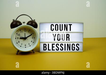 CountYour Segenstext auf Leuchtkasten mit Wecker auf gelbem Hintergrund Stockfoto