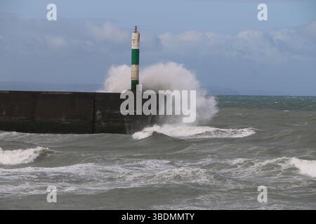 Aberystwyth Wales UK Weather 25th May 2025, Ein windiger Tag über der Westwales Küste mit verstreuten, schweren und stürmischen Schauern. Große Wellen schlagen gegen die Strandpromenade und das Hafenlicht. Quelle: mike davies/Alamy Live News Stockfoto