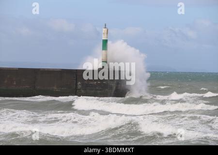 Aberystwyth Wales UK Weather 25th May 2025, Ein windiger Tag über der Westwales Küste mit verstreuten, schweren und stürmischen Schauern. Große Wellen schlagen gegen die Strandpromenade und das Hafenlicht. Quelle: mike davies/Alamy Live News Stockfoto