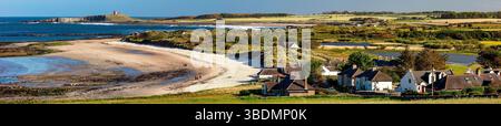 Blick im Frühling an einem sonnigen Tag mit Blick auf Dunstanburgh Castle an der Northumberland Coast von Low Newton-by-the-Sea bei Ebbe Stockfoto