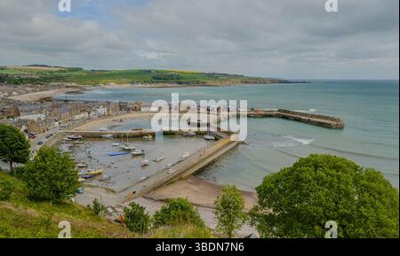 Der Hafen oder Hafen von Stonehaven an der Ostküste Schottlands bei Ebbe mit Booten und Yachten am Strand. Nordsee im Hintergrund. Steinhäuser Stockfoto