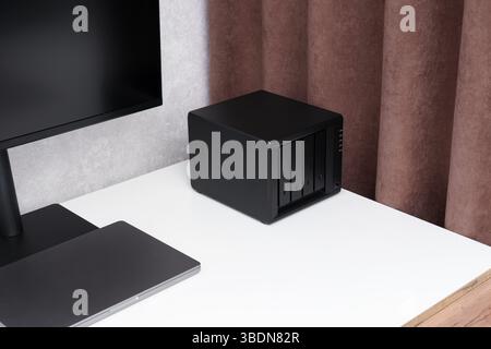 Netzwerkspeicher. NAS-Server. Gerät zum Sichern wichtiger Informationen auf einem weißen Desktop in der Nähe eines Computers. Für zu Hause oder im Büro. Stockfoto
