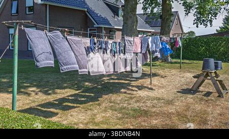 Die Handtücher, Geschirrtücher und Socken, die mit Stiften gesichert sind, trocknen an der Wäschelinie, Provinz Friesland, Niederlande Stockfoto