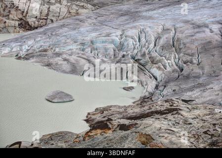 Gletscher bewegen sich immer vorwärts. Es sind ihre Ränder, die zurückschmelzen. Der Rhonegletscher 2015. Die Leinwandabdeckung ist ein Versuch, den Rückzug zu verlangsamen. Stockfoto