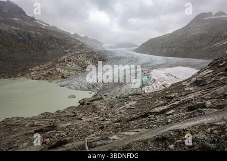Gletscher bewegen sich immer vorwärts. Es sind ihre Ränder, die zurückschmelzen. Der Rhonegletscher 2015. Die Leinwandabdeckung ist ein Versuch, den Rückzug zu verlangsamen. Stockfoto