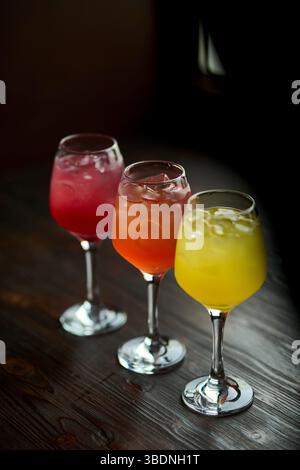 Cocktails auf einem Holztisch. Bunte Cocktails in Gläsern Stockfoto