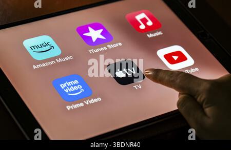 In dieser Fotoabbildung tippt eine Person am 24. Mai 2025 in Neu-Delhi, Indien, Asien auf Apple TV App-Symbole auf einem Tablet-Gerät Stockfoto