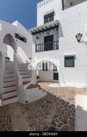 Enge Straße mit weißen Häusern im malerischen Dorf Binibequer auf der spanischen Insel Menorca. Stockfoto