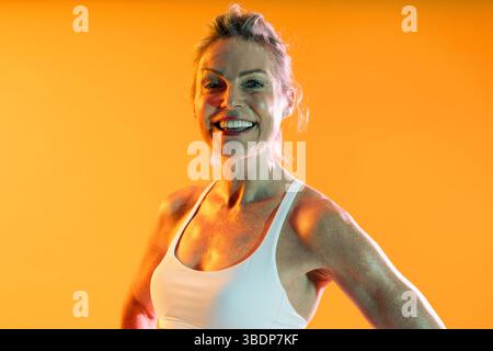 Schöne reife sportliche Frau, die Sportswear trägt, beim Training - glückliche sportliche reife Frau, die Sportkleidung trägt Stockfoto