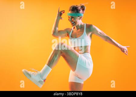 Schöne reife sportliche Frau mit Sportbekleidung beim Training – sportliche reife Frau strahlt Energie und Selbstvertrauen aus, während sie eine dynamische Arbeit verrichtet Stockfoto