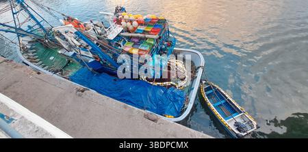 Fischereifahrzeug angedockt, beladen mit bunten Netzen und Ausrüstung Stockfoto