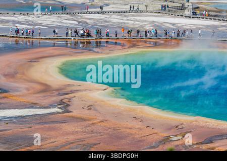 Parkbesucher auf der Aussichtsplattform können die Grand Prismatic Spring im Midway Geyser Basin des Yellowstone National Park, Wyomin, aus nächster Nähe betrachten Stockfoto