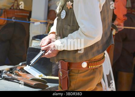 Cowboy-Reenactor, der seinen Colt 45 auf den Straßen von Tombstone, Arizona, nachlädt Stockfoto
