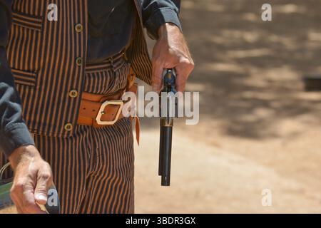 Cowboy-Reenactor, der seinen Colt 45 auf den Straßen von Tombstone, Arizona, nachlädt Stockfoto