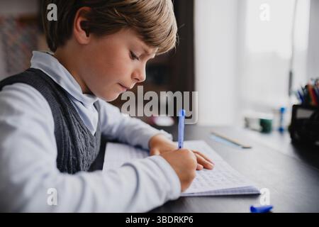 Junge Schüler macht seine Hausaufgaben zu Hause Stockfoto