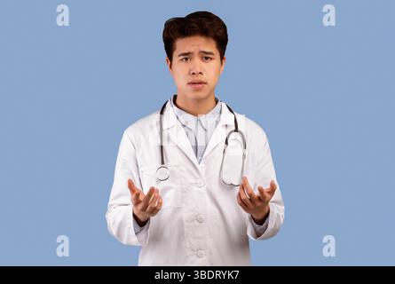 Asian Kerl im medizinischen Mantel im Gespräch mit Kamera, gestikuling Stockfoto
