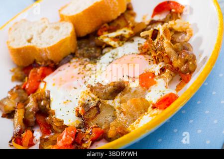 Eier gebraten mit Schweinefleisch und Tomaten Stockfoto