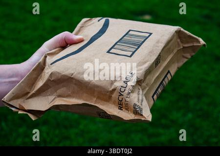 San Francisco, CA, USA – 24. Mai 2025: Eine Person im Freien hält ein Amazon Prime Paket, was die Einfachheit und Beliebtheit des Amazon-Versanddienstes symbolisiert. Stockfoto