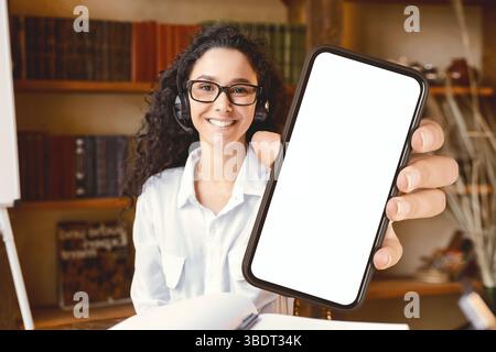 Frau trägt Kopfhörer, zeigt Daumen nach oben Geste Stockfoto