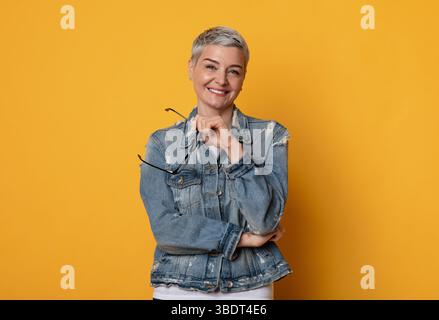 Porträt Der Schönen Lächelnden Dame Mittleren Alters Mit Brille In Den Händen Stockfoto