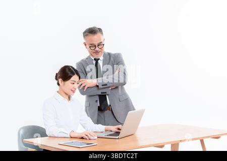 Ein geschäftlicher älterer Mann und eine junge Frau stehen (sitzend) am Schreibtisch Stockfoto