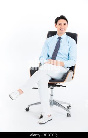 Ein passender Mann, der auf einem Bürostuhl sitzt, lächelt in die Kamera Stockfoto