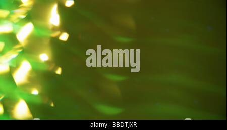 Funkelnde Lichtreflexion. Verschwommene Festivalkunst. Geometrische grüne Farbe glänzende Textur Partikel wirbeln auf modernem Bokeh heller Hintergrund. Stockfoto