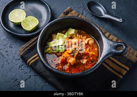 Scharfe rote Currysuppe mit Huhn, Garnelen und Avocado Stockfoto