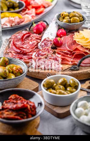 Verschiedene Vorspeisen und Antipasti-Platten auf Holztablett, Catering-Konzept mit Aufschnitt und Käse Stockfoto