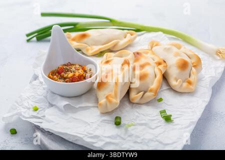 Traditionelle Empanadas mit Chimichurri-Sauce. Lateinamerikanische Küche. Stockfoto