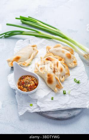Traditionelle Empanadas mit Chimichurri-Sauce. Lateinamerikanische Küche. Stockfoto