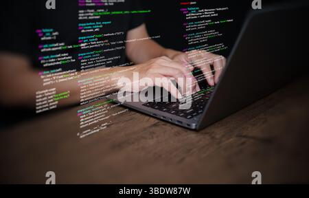Hände eines Programmierers geben auf einem Laptop Programmiercode ein, der Programmiercode anzeigt, der Codierungstechnologie, Softwareentwicklung und Webanwendungen symbolisiert. IT-Lösungen, an Stockfoto