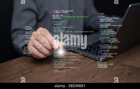 Hände eines Programmierers geben auf einem Laptop Programmiercode ein, der Programmiercode anzeigt, der Codierungstechnologie, Softwareentwicklung und Webanwendungen symbolisiert. IT-Lösungen, an Stockfoto