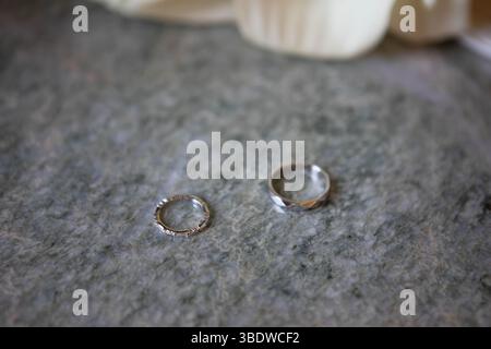 Goldene Ringe mit Diamanten auf weißem Hintergrund. Stillleben und kreatives Foto mit Schatten. Diamantringe gruppieren minimales Konzept Stockfoto