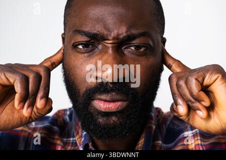 Nahaufnahme Porträt eines müden und überarbeiteten schwarzen Mannes, der niemandem zuhören kann. Stockfoto