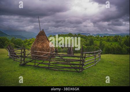 Traditionelle Haystacks und ländliche Berglandschaft in Rumänien regnerischer Sommer. Stockfoto