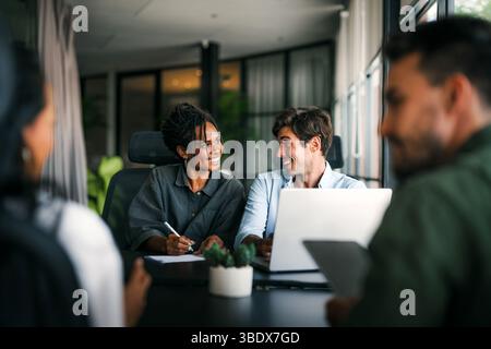 Team aus Spezialisten für Industriedesign und Softwareentwicklern, die im Büro diskutieren Stockfoto