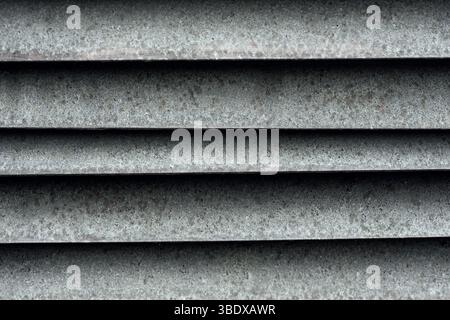 Nahaufnahme eines rostigen Industriemetallventilgitters mit horizontaler Lattenstruktur Stockfoto