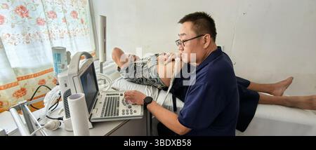 Suva. Mai 2025. Der chinesische Arzt Tang Jiande führt am 22. Mai 2025 eine Ultraschalluntersuchung bei einem lokalen Patienten auf der Insel Eua in Tonga durch. ZU GEHEN MIT 'Feature: Chinesisches medizinisches Team bringt Hoffnung zu ländlichen Bewohnern in Tonga' Credit: Xinhua/Alamy Live News Stockfoto