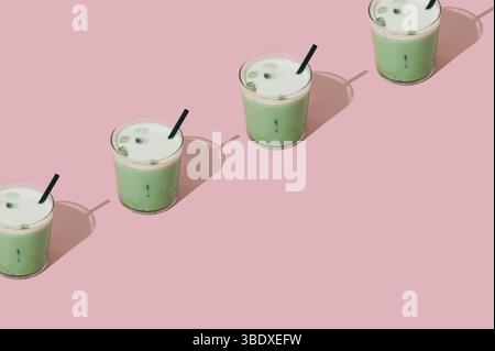Kreatives Sommermuster aus gefrorenem Matcha-Latte auf pastellrosa Hintergrund mit Kopierraum. Minimales gesundes Matcha Latte Konzept. Trendige Drink-Idee. Stockfoto