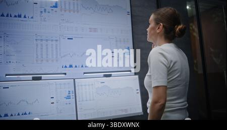 Weibliche Börsenhändlerin telefoniert, überwacht Echtzeitaktien und Börsenkarten auf Multi-Monitor-Computern und digitalen Tablets. Investmentagenten Betonten Schlechte Wirtschaftsnachrichten. Stockfoto