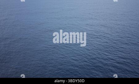 Der ruhige Blick auf das Meer zeigt unendliche Weiten des tiefblauen Wassers unter klarem Himmel, was Ruhe und Gelassenheit in einer isolierten und natürlichen Umgebung im Freien hervorruft Stockfoto