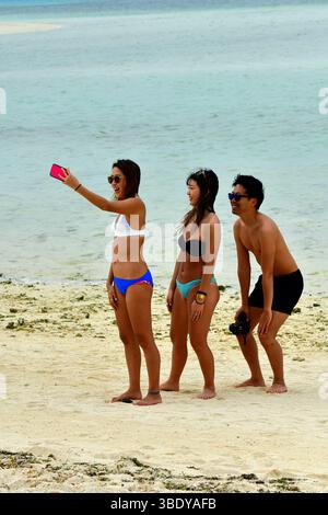Gruppe junger Leute, die ein Selfie am Kondoi Strand auf der Insel Taketomi in der Präfektur Okinawa, Japan, Asien machen. Stockfoto