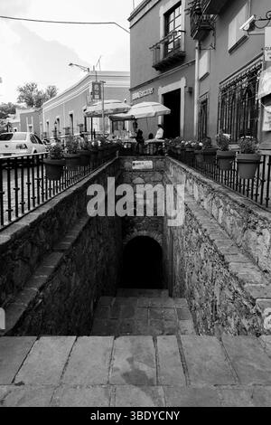 Guanajuato City, Mexiko - 30. Mai 2016: Eine Steintreppe führt hinunter in einen dunklen Tunnel, in dem Menschen an Tischen sitzen. Stockfoto