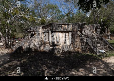 Chichen Itza, Mexiko - 25. Februar 2019: Ein Steinbau mit Treppen und Schnitzereien wird von Touristen gesehen und zeigt Maya-Architektur. Stockfoto